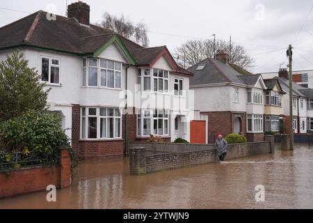 A person walks through floodwater in Greyfriars Avenue in Hereford, Herefordshire, after Storm Darragh hit the UK and Ireland. Picture date: Sunday December 8, 2024. Stock Photo