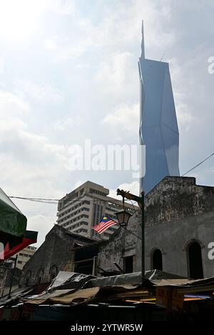 The Merdeka 118 juxtaposed against traditional Straits Chinese style shophouses and hawker market stalls in Chinatown KL along Jalan Petaling Stock Photo