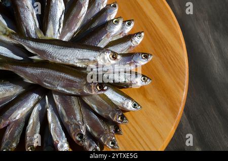 Dried fish bleak on a wooden board. Very tasty, fatty fish for beer. Stock Photo