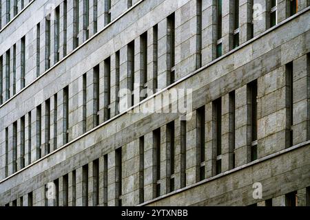 Modern Office Building Facade with Repetitive Windows and Stone Exterior Stock Photo