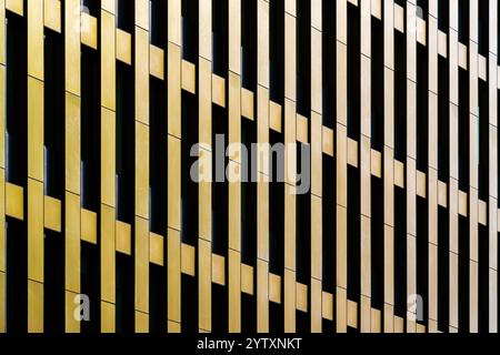 Abstract Golden Facade with Vertical Panels and Geometric Repetitions in Modern Architecture Stock Photo