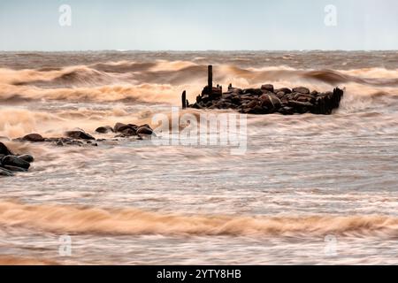 dramatic storm in the Baltic Sea, large waves crashing against the stone pier, blurred, unclear contours, rocky shore of Vidzeme, Thuja, Latvia Stock Photo