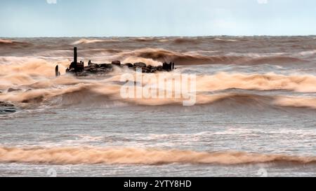 dramatic storm in the Baltic Sea, large waves crashing against the stone pier, blurred, unclear contours, rocky shore of Vidzeme, Thuja, Latvia Stock Photo