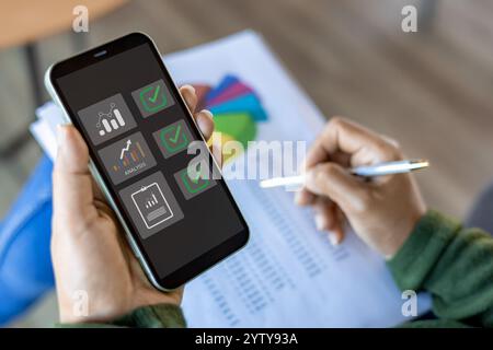 Using mobile smartphone, Business woman working with balance sheet of accounting for calaulating finance, tax, accounting, statistics and analytic res Stock Photo