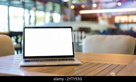 Laptop with blank screen and placed on a wooden table inside a coffee shop. Workspace background new project on laptop computer with blank copy space Stock Photo