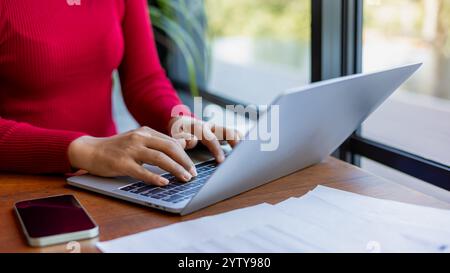 Women working about new startup on laptop to analysis finance of project, Woman holding a pen while working at office, Close up shot hands of woman us Stock Photo