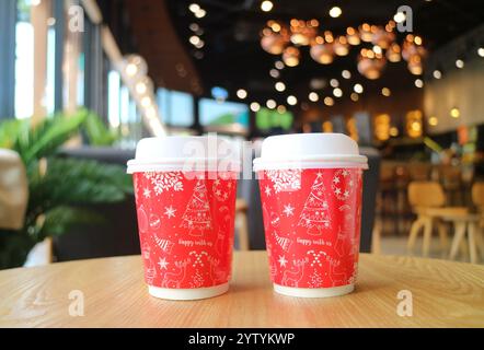 Pair of Red and White Takeaway Christmas Coffee Cup on the Table Stock Photo