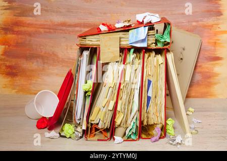 messy file folders and business records ,red tape, bureaucracy,red tape,,overworked,beat the clock business concept on grungy blue backgound. Stock Photo