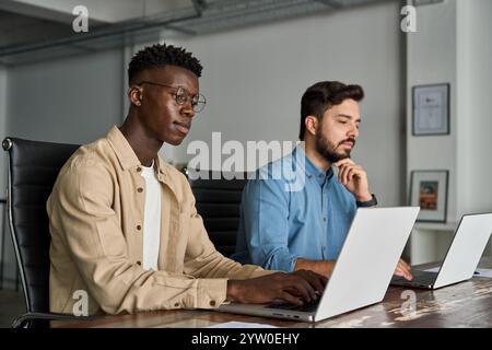 Two busy diverse business men company employees using laptops working in office. Stock Photo