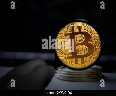 A golden Bitcoin coin magnified against a dark background, emphasizing the intricate design and symbolic power of digital currency in the modern world Stock Photo