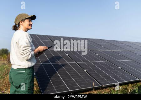Female farmer with digital tablet on a modern farm using solar panels. Stock Photo