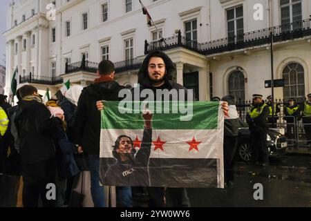 London, UK. 8th December, 2024. British-Syrians gathered to celebrate the ending of the Assad regime in Trafalgar Square, where later a large group marched on to the Syrian Embassy, calling for the flag of the previous government to be taken down from the building and replaced with the three red starred flag opposition forces has been seen with. Credit: Eleventh Hour Photography/Alamy Live News Stock Photo