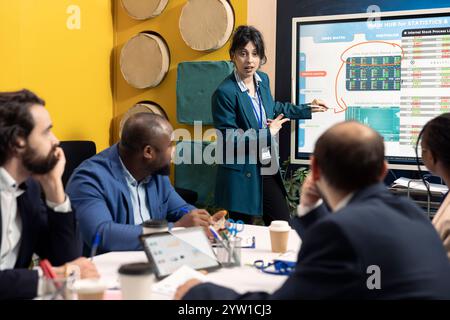 Team of corporation employees preparing pitch for stakeholders meeting, working on ways to increase profit. Coworkers attending a conference to address financial updates. Stock Photo