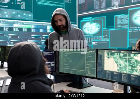 Governmental hackers analyzing big data for cyber threat detection, working at agency desks. Professional expert woman analyzes cyber intelligence and prevention of digital threats. Stock Photo