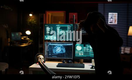 Hackers found by cybercriminal law enforcement escaping with stolen data on SSD after failing to conceal online identity. Criminal in hideout running from police after hacking into servers, camera B Stock Photo