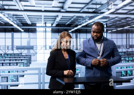 Engineers in data center tracking network traffic and activity using augmented reality, installing and configuring software updates. Coworkers performing database backups using AR holograms Stock Photo