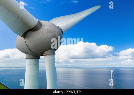 A single wind turbine stands tall in the middle of the lake Ijsselmeer, harnessing energy from the wind to generate electricity in the Noordoostpolder Netherlands, windmill turbines in the ocean Stock Photo