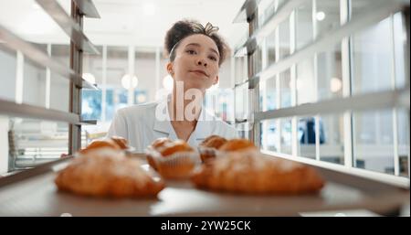 Croissant, bakery and pastry with woman in kitchen for coffee shop, food industry and breakfast. Shelf, chef and nutritionist with baker and dessert Stock Photo