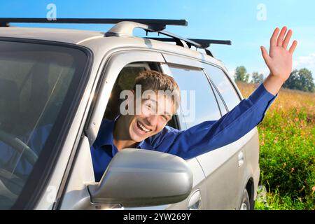 happy young man sit in the car and give salute gesture Stock Photo