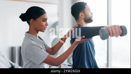 Care, man and woman in physiotherapy with dumbbell for fitness, muscle workout or exercise. Rehabilitation, physiotherapist and patient in office Stock Photo