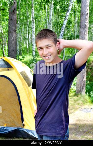 Happy young Man camping in the forest Stock Photo