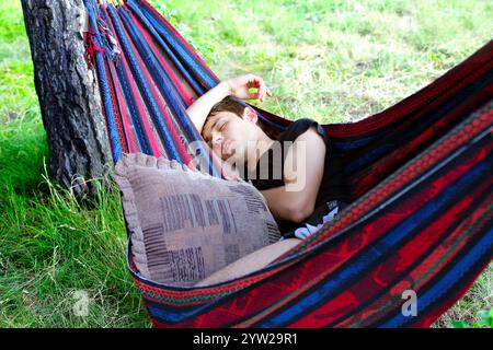 Young Man sleeping in the Hammock on the Nature Stock Photo