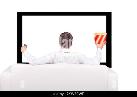 Teenager with Remote Control and Popcorn sitting on the Sofa and watching Tv-set Stock Photo