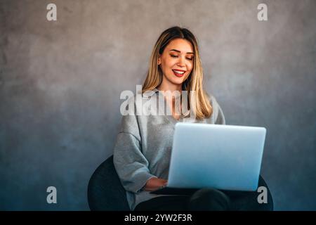 Young female designer, freelancer working in the office. Female using laptop to searching info. Stock Photo