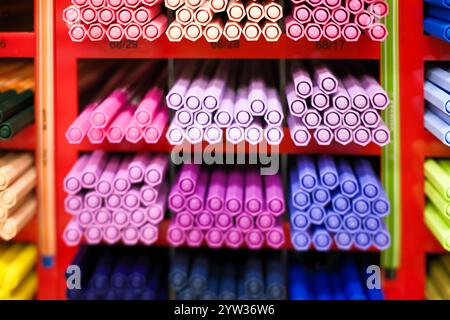 Colorful markers and pens arranged neatly on a store display rack with a focus on the pink tones. Stock Photo