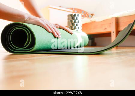 Green yoga mat close-up with a cozy home background Stock Photo