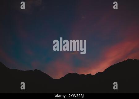 Mountains silhouetted against a orange and blue sunset Stock Photo