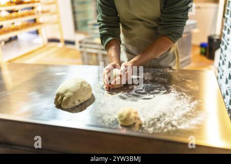 Close-up of hands of a male latin baker kneading dough at workshop of an artisan bakery Stock Photo