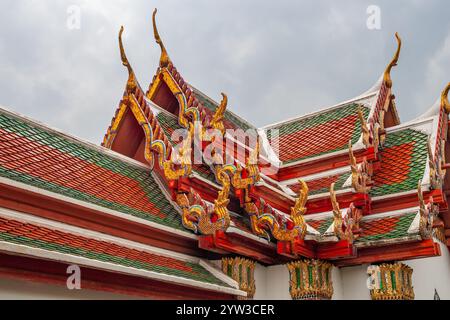 Tiled roofs with finials and gilded ornamentation at the Grand Palace in Bangkok, Thailand. Stock Photo