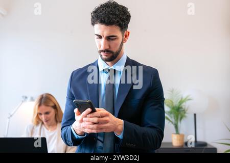Focused Businessman Using Smartphone in Modern Office Setting Stock Photo
