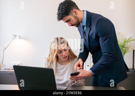Business Colleagues Collaborating with Smartphone in Modern Office Stock Photo