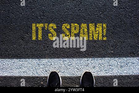 It's spam message written on asphalt road. Conceptual it's spam symbol. Copy space. Stock Photo