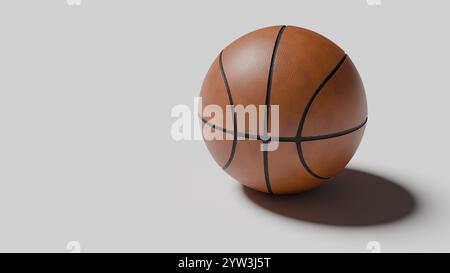 basketball sits on a smooth surface, casting a soft shadow. Its detailed texture and design are prominently displayed, highlighting the brown leather Stock Photo