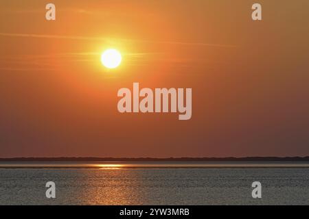 Sunset over the North Sea at low tide, the outline of the island of Juist on the horizon, Norddeich, Lower Saxony, Germany, Europe Stock Photo