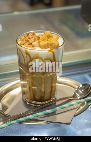 A glass of iced coffee with cream and caramel on a tray, served with a straw and spoon, autumn creations, Cafe Kuh, Deckenpfronn, Black Forest, German Stock Photo