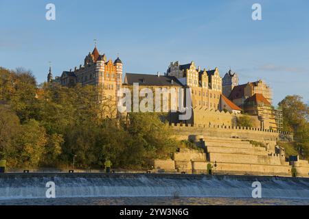 A castle on a hill above a river in autumnal surroundings with blue sky and sunset, Bernburg Castle, Bernburg an der Saale, Saxony-Anhalt, Germany, Eu Stock Photo