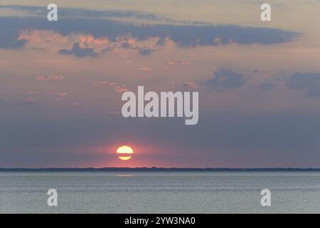 Sunset over the calm North Sea, the outline of the island of Juist on the horizon, Norddeich, Lower Saxony, Germany, Europe Stock Photo