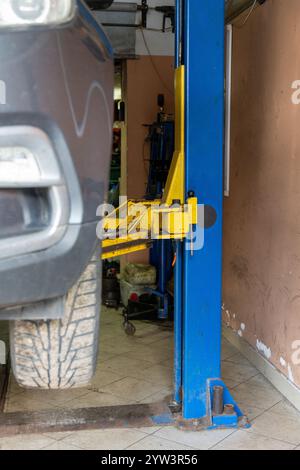 Car repair maintenance service. Car raised on car lift in autoservice ...