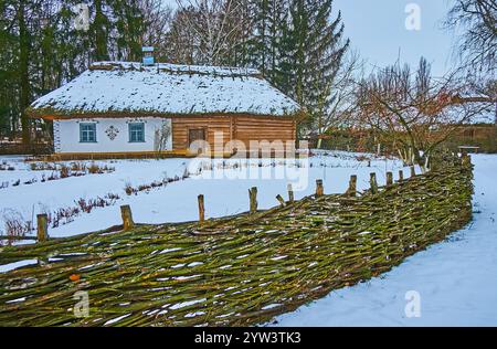 The winter Pereiaslav Scansen with a view of traditional medieval village house and tyn wicker fence, Ukraine Stock Photo