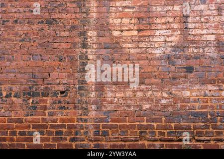 Antique brick wall with remnants of painted letters Stock Photo