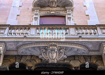 Murcia, Spain - October 25, 2024: Stone decorations in the support structures of balconies in a facade of an old building. Stock Photo