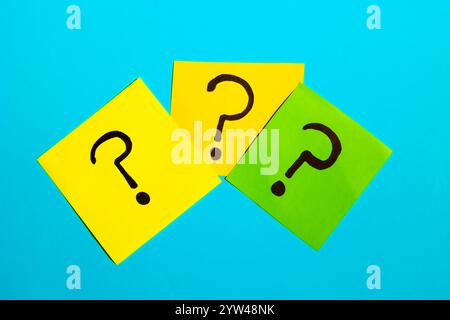 Three sticky notes with question marks on a blue background, question concept Stock Photo
