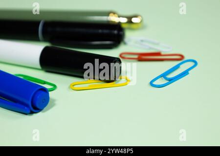 Close up of multicolored markers, highlighters and paper clips scattered on a light background. working materials Stock Photo