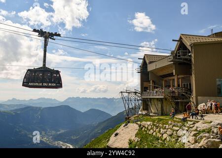 A cabin leaving the Plan de l'Aiguille cable car station (2317 m) to reach the Aiguille du Midi (3842 m), with hikers in summer, Chamonix, France Stock Photo