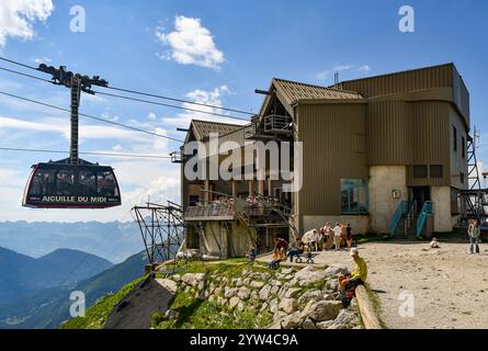 A cabin leaving the Plan de l'Aiguille cable car station (2317 m) to reach the Aiguille du Midi (3842 m), with hikers in summer, Chamonix, France Stock Photo