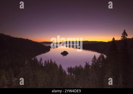 As the sun rises over Emerald Bay in Lake Tahoe, the sky is painted with a mesmerizing display of vibrant colours, reflecting off the tranquil waters Stock Photo